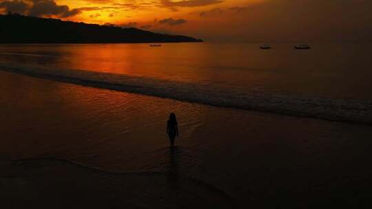 航拍夕阳下美女在海边沙滩散步日落黄金海岸