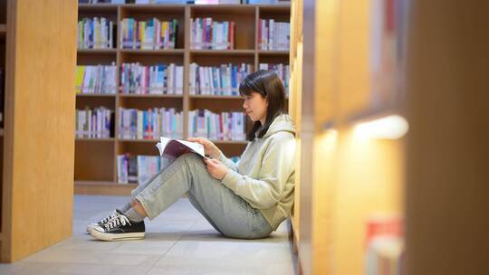 年轻女子图书馆在书架前翻看书本学习视频素材模板下载