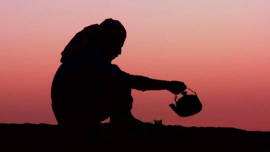 贝都因人在夕阳下喝茶