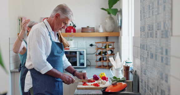 老夫妇，在厨房做饭和蔬菜或一起健康饮食或