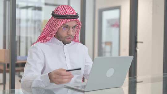 年轻的阿拉伯男子用信用卡享受网上银行