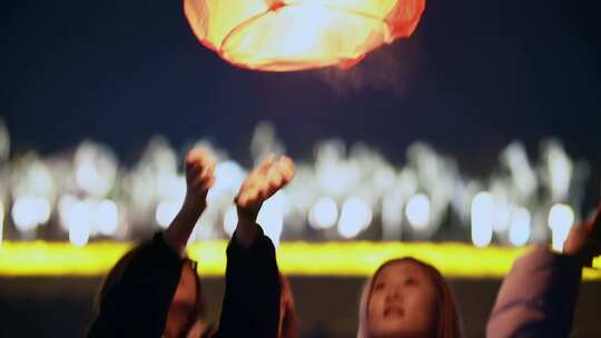 夜晚年轻人放孔明灯