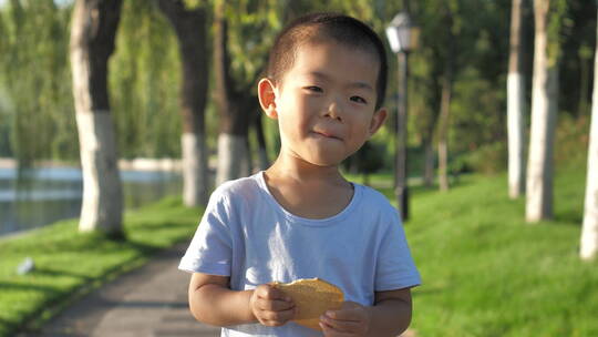 小朋友在公园树林中吃饼干玩玩具