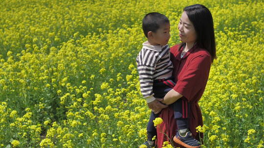 春天中国女性和小朋友在油菜花田地中玩耍