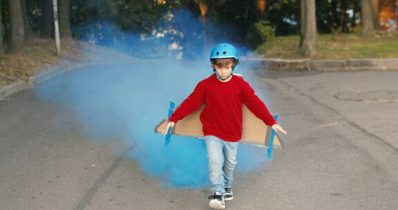 小男孩戴着烟雾飞行器奔跑