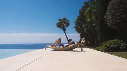 比基尼美女躺在海边沙滩椅晒太阳享受阳光