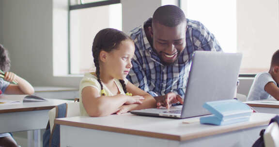 快乐的非裔美国男老师用笔记本电脑帮助高加索女孩的视频