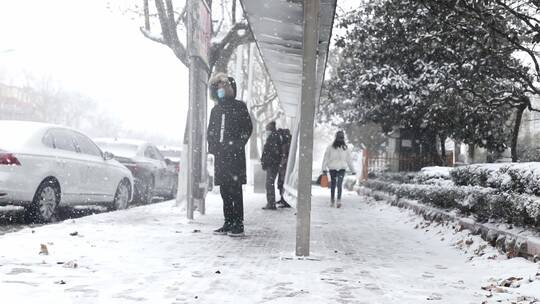 在大雪中等公交车的市民