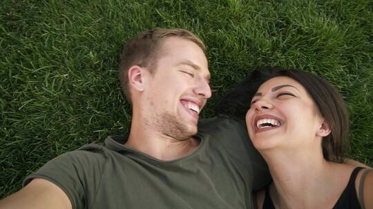 开心的情侣躺在草地上