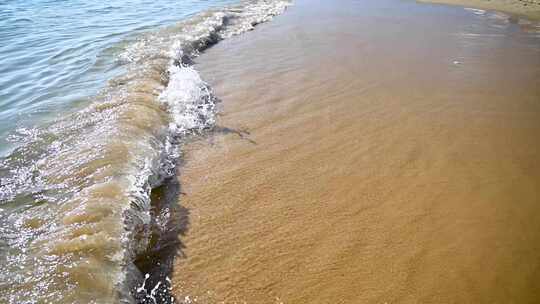 海岛阳光下海浪浪花冲刷沙滩