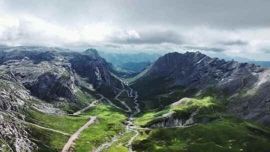 蓝天白云下甘南扎尕那的山脉和山谷中的公路