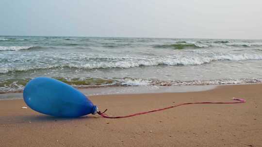 沙滩上的蓝色气球与海浪 4K