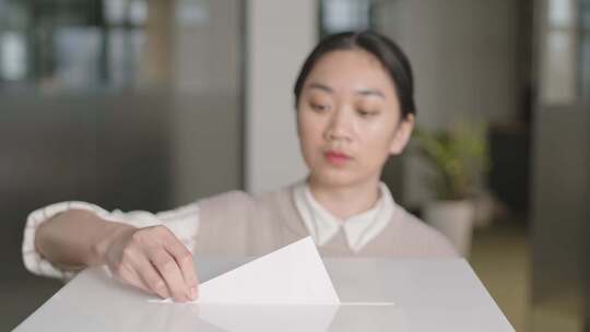 女人把选票投在投票箱上