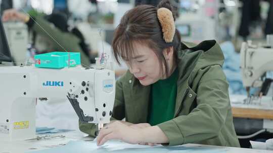 制衣厂女工缝纫工认真缝纫衬衣作业