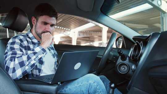 看着笔记本电脑屏幕的人在车里慢动作喝咖啡