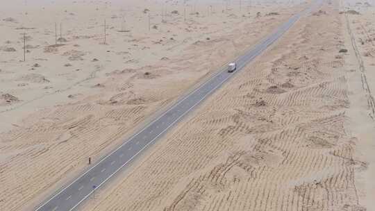航拍货车行驶在新疆塔克拉玛干沙漠公路上