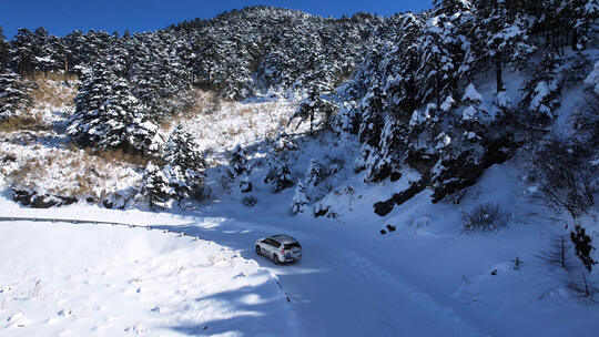 航拍冬天湖北神农架雪景山路行驶的汽车