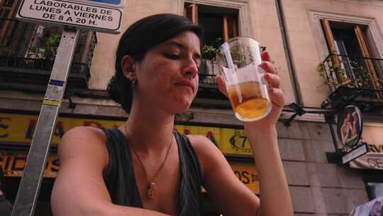 4k慢动作。美丽的高加索女人在马德里（西班牙）的一家酒吧喝啤酒。西班牙女孩西蒂
