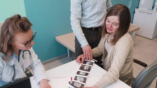孕妇夫妇在医生的指导下看B超影像