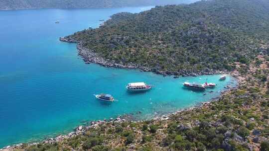 潜水旅游船停泊在土耳其的一个小海湾和游客度假者在海里游泳