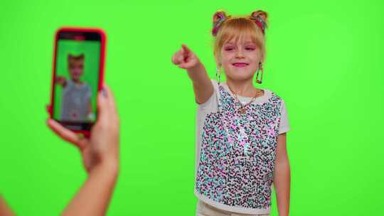 快乐的时髦博客儿童女孩在智能手机上为社交网络录制有趣的舞蹈视频