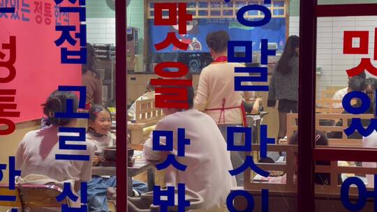 橱窗韩国料理店吃饭的人