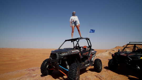 站在沙漠越野沙滩车顶上的女子视频素材模板下载