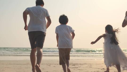 一家人幸福的在沙滩奔跑