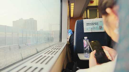 高铁车厢里靠窗玩手机