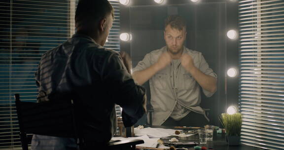 男演员对着镜子练表情