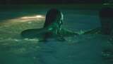 女人在绿色灯光的游泳池里把男人浸泡在水下高清在线视频素材下载