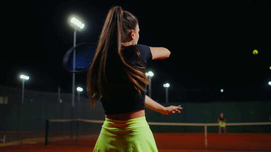 美丽的年轻女子在户外球场打网球