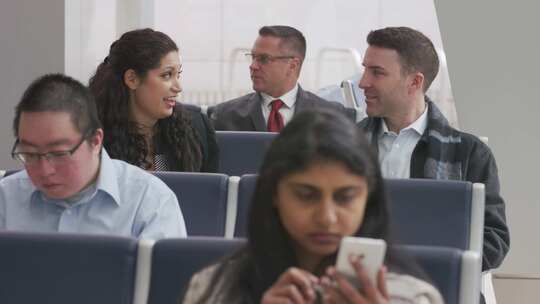 一男一女在机场坐在乘客旁边聊天