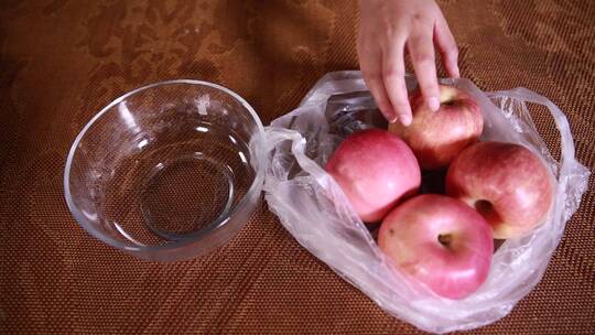塑料袋装刚买回的苹果放进果盘
