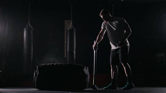 男子用铁锤击打轮胎锻炼臂力视频素材模板下载