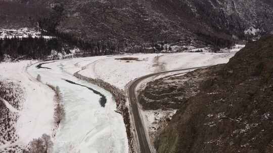 汽车在岩石和结冰的卡顿河之间的道路上行驶