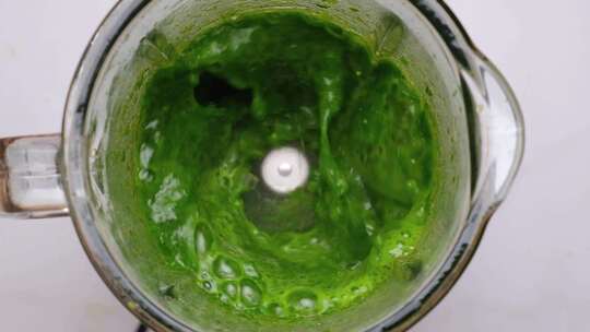 在搅拌机中烹饪绿色蔬菜冰沙菠菜叶在搅拌机
