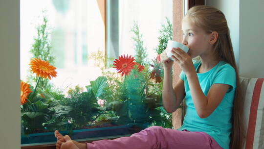 坐在窗台上吃饼干喝茶的女孩视频素材模板下载