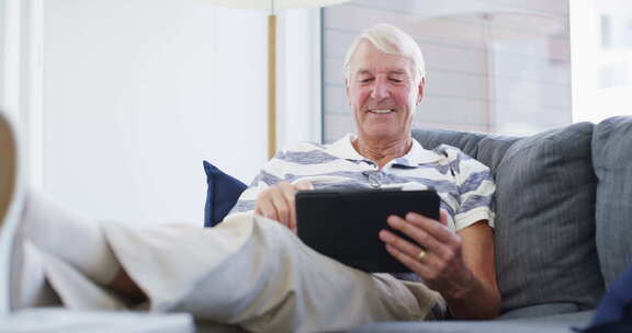 平板电脑、放松和老人坐在沙发上，家里有社