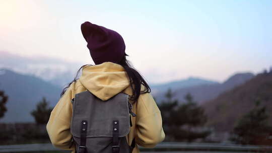 Active Travel背包客女人在日落景观中漫步欣赏雪山顶峰返回视图