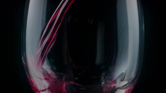 在黑色背景上看到的玻璃杯里倒红酒