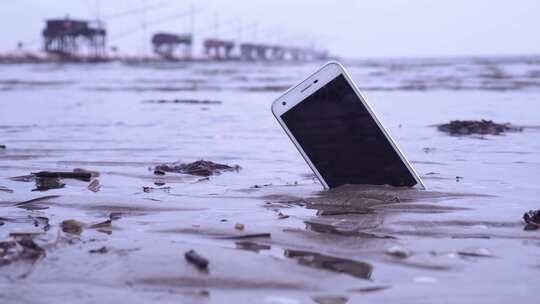 智能手机被困在大海的沙子里