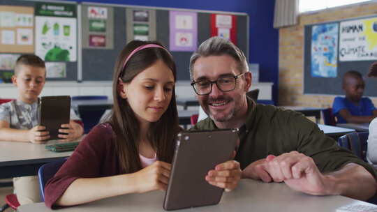 不同的男老师帮助一个女学生坐在教室里使用平板电脑