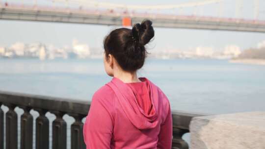 年轻胖乎乎的女性沿着城市河流和桥梁进行北欧式散步的特写镜头