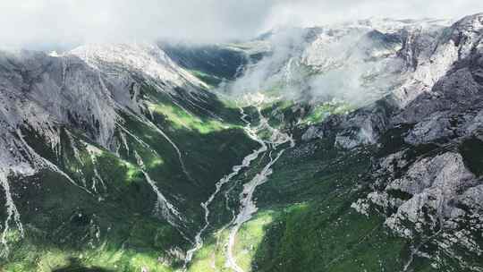 蓝天白云下甘南扎尕那的山脉和山谷中的公路