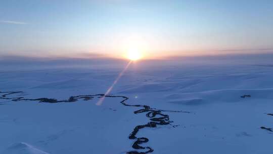 辽阔雪原蜿蜒冰封河流唯美夕阳