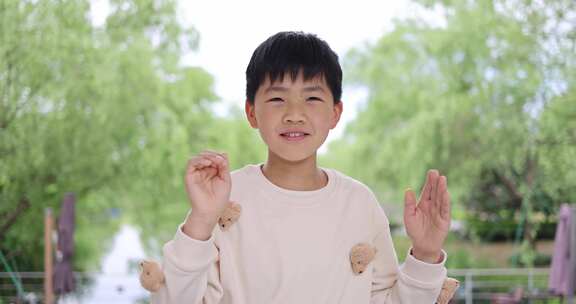 可爱的中国小男孩做手势鼓掌唯美慢镜