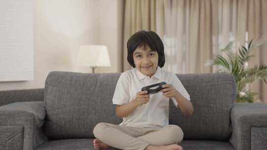 快乐的印度男孩玩电子游戏