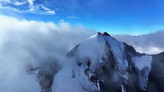 航拍四川甘孜云雾缭绕的乌库楚雪山风光