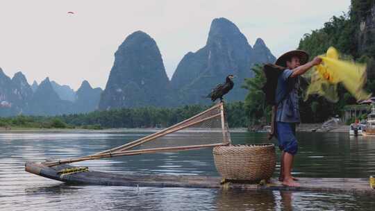 桂林漓江渔民在山水间撑竹筏撒网捕鱼的场景